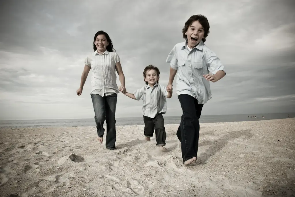 A family running together on a beach